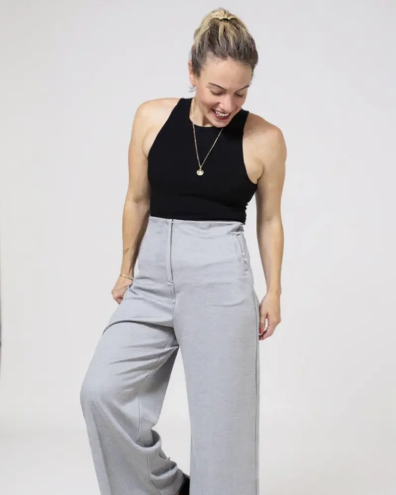 Top negro con pantalón de sastre gris, de Mena